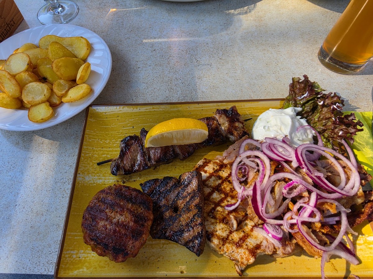 Griechischer Grillteller mit Bifteki, Souflaki-Spieß und roten Zwiebeln bei der Gaststätte Frühlingsau