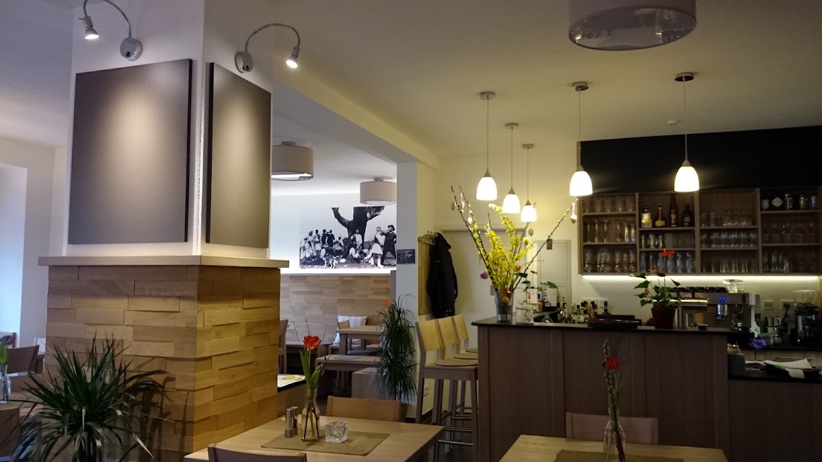 Gemütlicher Innenraum der Gaststätte Frühlingsau mit Bar und griechischem Wandbild